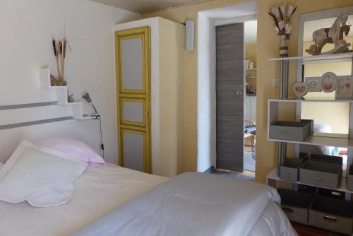 a bedroom with a white bed and a yellow door at La petite Galéjade in Gordes