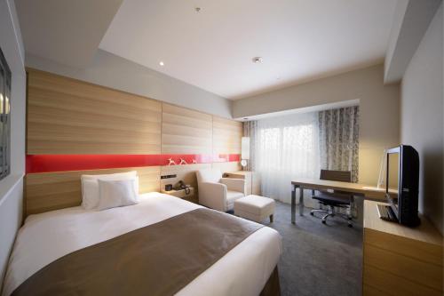 a hotel room with a bed and a desk at Hotel Metropolitan Akita in Akita
