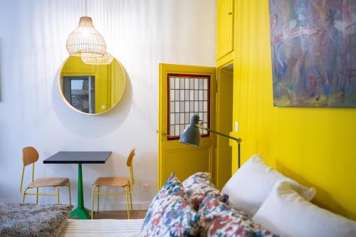 salon z żółtymi drzwiami i stołem w obiekcie Le Studio Gab's - Coup de coeur déco tout confort w mieście Caluire-et-Cuire