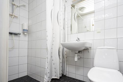 a white bathroom with a toilet and a sink at Daftö Resort in Strömstad