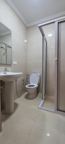 a white bathroom with a toilet and a sink at El balcón del mediterráneo in M'diq