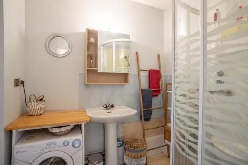 une salle de bain avec un lavabo et une machine à laver dans l'établissement Mauresque, à Arcachon
