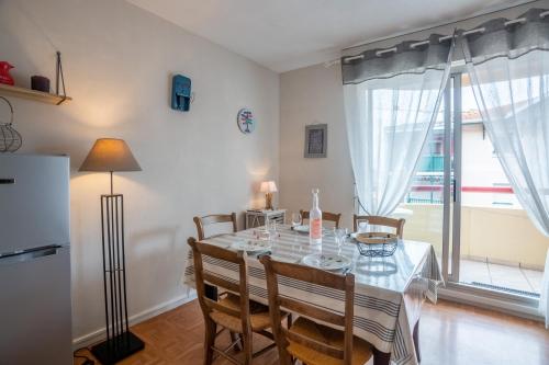 d'une salle à manger avec une table, des chaises et un réfrigérateur. dans l'établissement Mauresque, à Arcachon