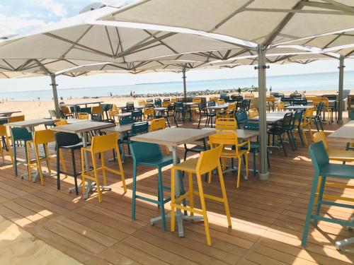 シャトライヨン・プラージュにあるHôtel Restaurant L'Atelier des Cousinsのビーチの傘下のテーブルと椅子