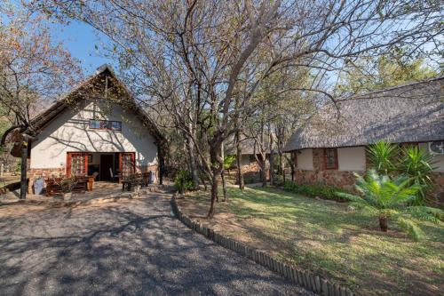 
a house with a tree in front of it at Blyde River Canyon Lodge in Hoedspruit
