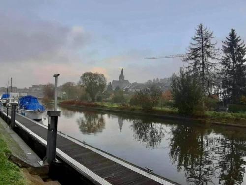 a river with a boat parked next to a dock at 't Hof van Cremers in Geraardsbergen