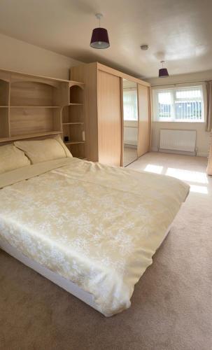 um quarto com uma grande cama branca num quarto em Large 4 bedroom home in Boston Spa village In-between York, Harrogate and Leeds, Sleeps 9 em Boston Spa