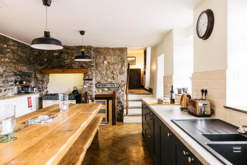 a kitchen with a wooden counter top and a stone wall at Our Holiday House Yorkshire, Ingleton - children and doggy friendly in Ingleton
