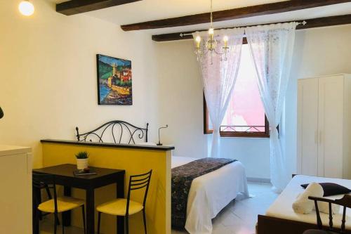 um quarto com uma cama, uma mesa e cadeiras em La Gianchina di Vernazza - Central Cozy Apt Wi-Fi em Vernazza