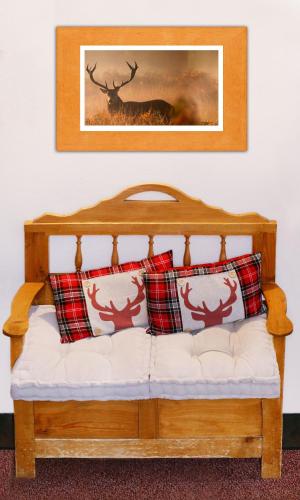 a wooden bed with pillows and a picture of a deer at Biotel Bertel Naturappartements in Brand