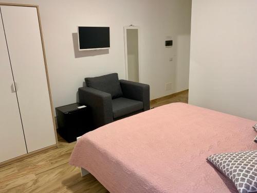 een slaapkamer met een stoel, een bed en een televisie bij B&B Di Fiore in Peschici