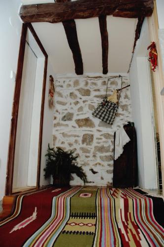 a room with a bed with a stone wall at The House in Shipka in Shipka