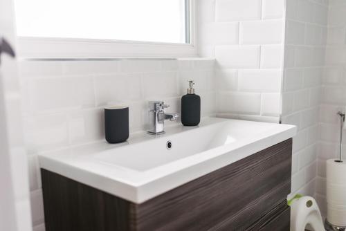 a bathroom sink with two soap dispensers on it at Our Holiday House Yorkshire, Ingleton - children and doggy friendly in Ingleton 
