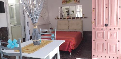 a room with a bed with a table and a pink cabinet at La graciosa in Costa Del Silencio