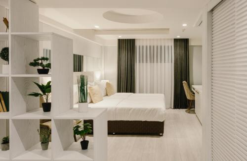 a bedroom with a bed in a room with plants at Original Boutique Hotel in Tbilisi City