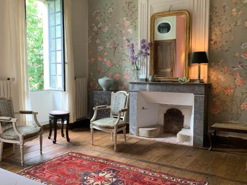 - un salon avec une cheminée, des chaises et un miroir dans l'établissement Chateau Mas de Pradie B&B Garden view room, à Foissac