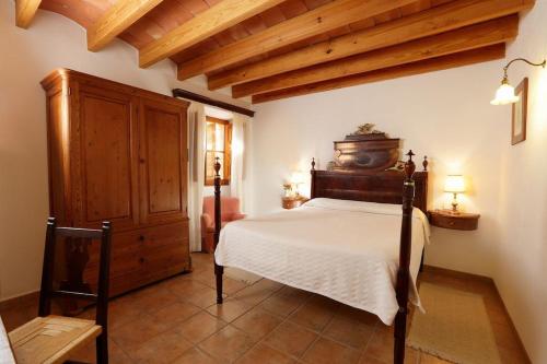 ein Schlafzimmer mit einem Bett und einem Holzschrank in der Unterkunft Son Malero in Calvià