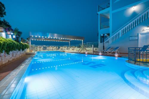 a large swimming pool at night at Denise Beach Hotel in Laganas