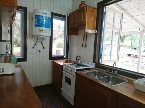 a kitchen with a sink and a stove and windows at Estancia las Mercedes in Eldorado