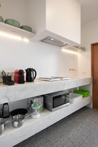 a kitchen with a counter with a microwave on it at urban beach sixties in Portimão