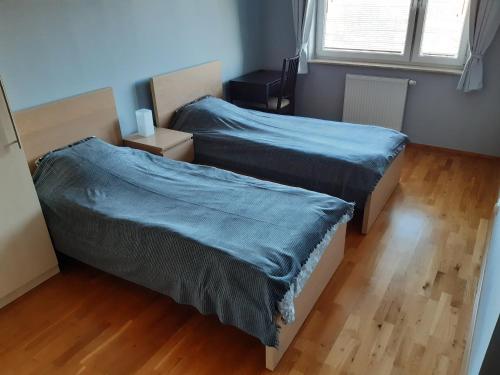 a bedroom with two beds with blue sheets at ParkView Apartment in Gdańsk
