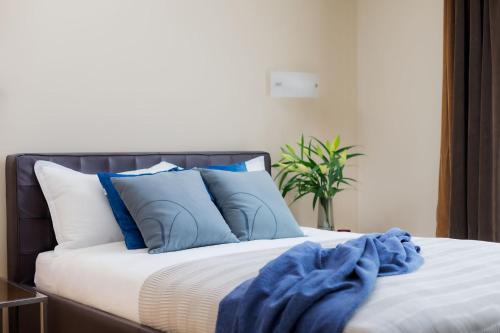 a bed with blue pillows and a blue blanket on it at VISIONAPARTMENTS Albertstrasse - contactless check-in in Zürich