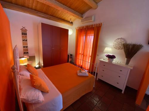a bedroom with a bed and a dresser and a window at Orecchie di Lepre in Siracusa