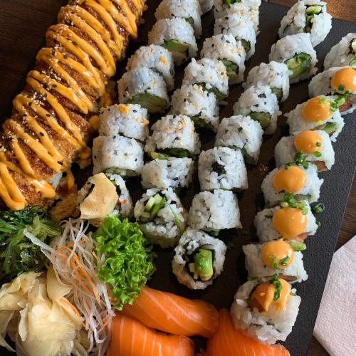 a plate with sushi and vegetables on a table at In the middle of Trysilfjellet - Welcome Center - Apartment with 3 bedrooms - By bike arena and ski lift in Trysil