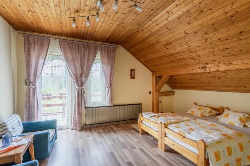 een slaapkamer met een bed en een houten plafond bij Gemenc Vendégház in Hercegszántó