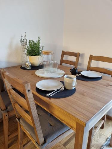 a wooden table with plates and dishes on it at Ferienwohnung Tostner Burgblick in Feldkirch