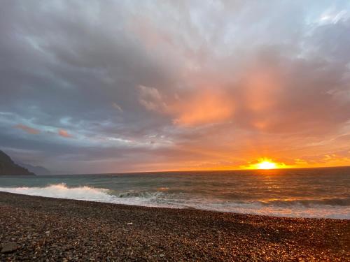 a sunset on a beach with the ocean at Chalet Kvariati in Kvariat'i