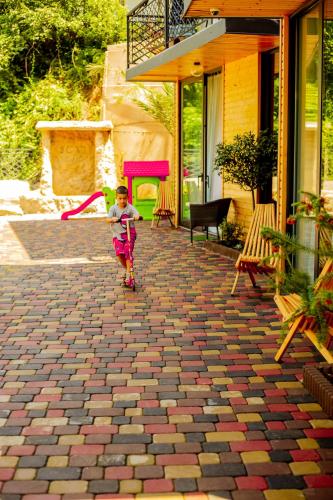 a young boy is walking on a brick patio at Chalet Kvariati in Kvariat'i