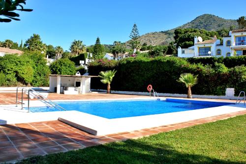 a swimming pool in a yard next to a house at Costadelsolflat in Benalmádena