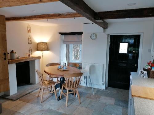 Il comprend une cuisine et une salle à manger avec une table et des chaises en bois. dans l'établissement Our Holiday House Yorkshire , Bentham - Children and doggy friendly, à High Bentham