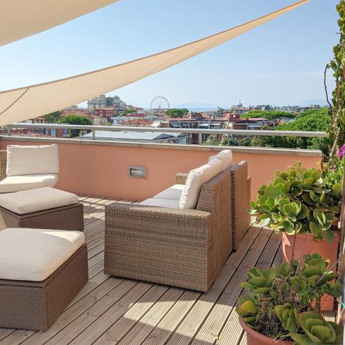 a balcony with wicker chairs and chairs on a roof at Hotel Piccolo Mondo in Lido di Camaiore