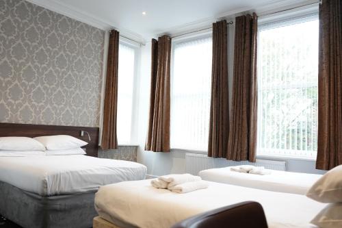 een hotelkamer met 2 bedden en een raam bij The Marlborough Hotel in Liverpool