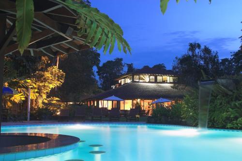 uma piscina em frente a uma casa à noite em Itamambuca Eco Resort em Ubatuba