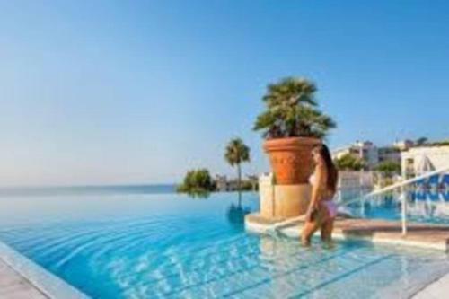 une femme qui marche dans l'eau dans une piscine dans l'établissement C036 Agréable appartement au sein d'une belle residence de vacances, à Cannes