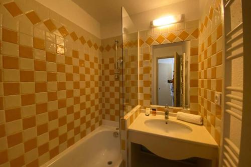 une salle de bain avec un lavabo, une baignoire et un miroir dans l'établissement C036 Agréable appartement au sein d'une belle residence de vacances, à Cannes