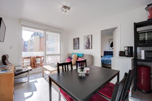 un salon avec une table de salle à manger et une cuisine dans l'établissement Tribord, à Courseulles-sur-Mer