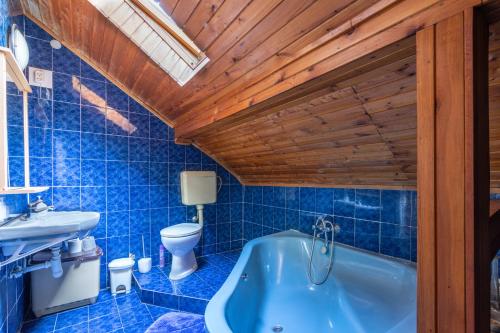 een blauwe badkamer met een toilet en een bad bij Gemenc Vendégház in Hercegszántó