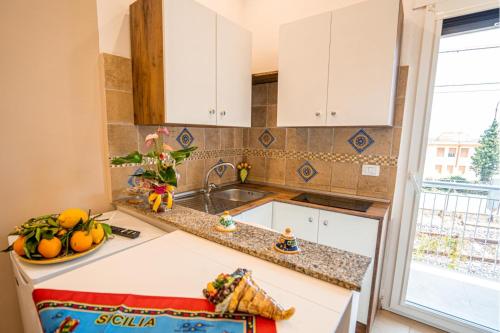 a kitchen with white cabinets and a sink at Vista Mare Apartments in Giardini Naxos