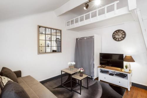 un salon avec un canapé et une télévision dans l'établissement Studio Labordette - Welkeys, à Biarritz