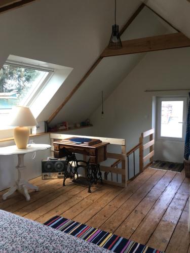 Cette chambre mansardée comprend un bureau et une fenêtre. dans l'établissement La maison du pêcheur, à Saint-Quay-Portrieux