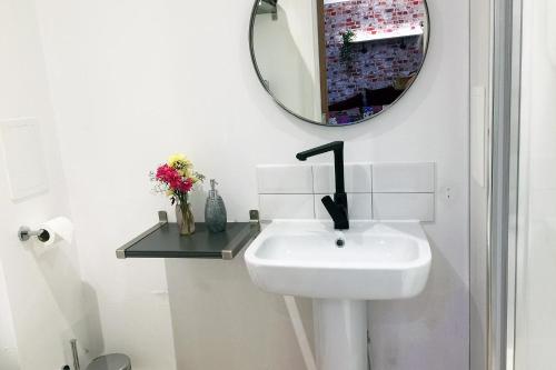 a bathroom with a sink and a mirror on the wall at Beaverhall Holiday Apartments in Edinburgh