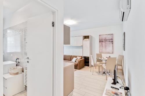 a kitchen and living room with white walls and a table at DREAM Holiday Houses in Cernobbio