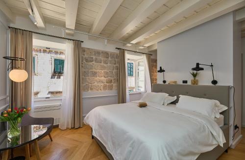 um quarto com uma grande cama branca e uma janela em Bota Palace em Dubrovnik