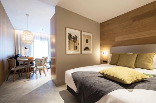 una camera da letto con un letto e un tavolo con sedie di Goodnight Cádiz Apartments a Cadice