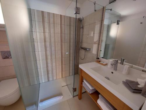 a bathroom with a shower and a sink and a toilet at Hôtel les Bouis - Vue mer in Saint-Tropez