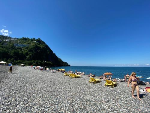 a group of people sitting on a beach at Chalet Kvariati in Kvariat'i